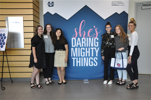 Students in front of She's daring mighty things poster